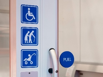 A disabled sign, an elderly sign, and a child in a pram sign on a wall.