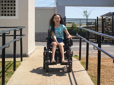 A person in a wheelchair using a ramp outside.