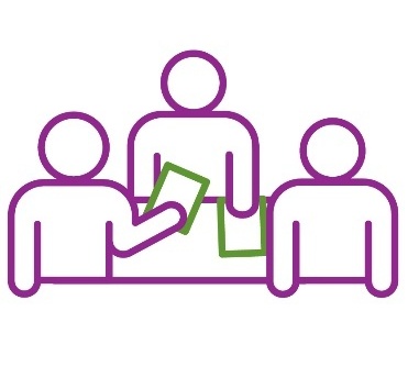 A group of people standing at a desk reading documents.