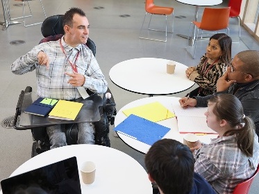 A diverse group of people working around a small table.